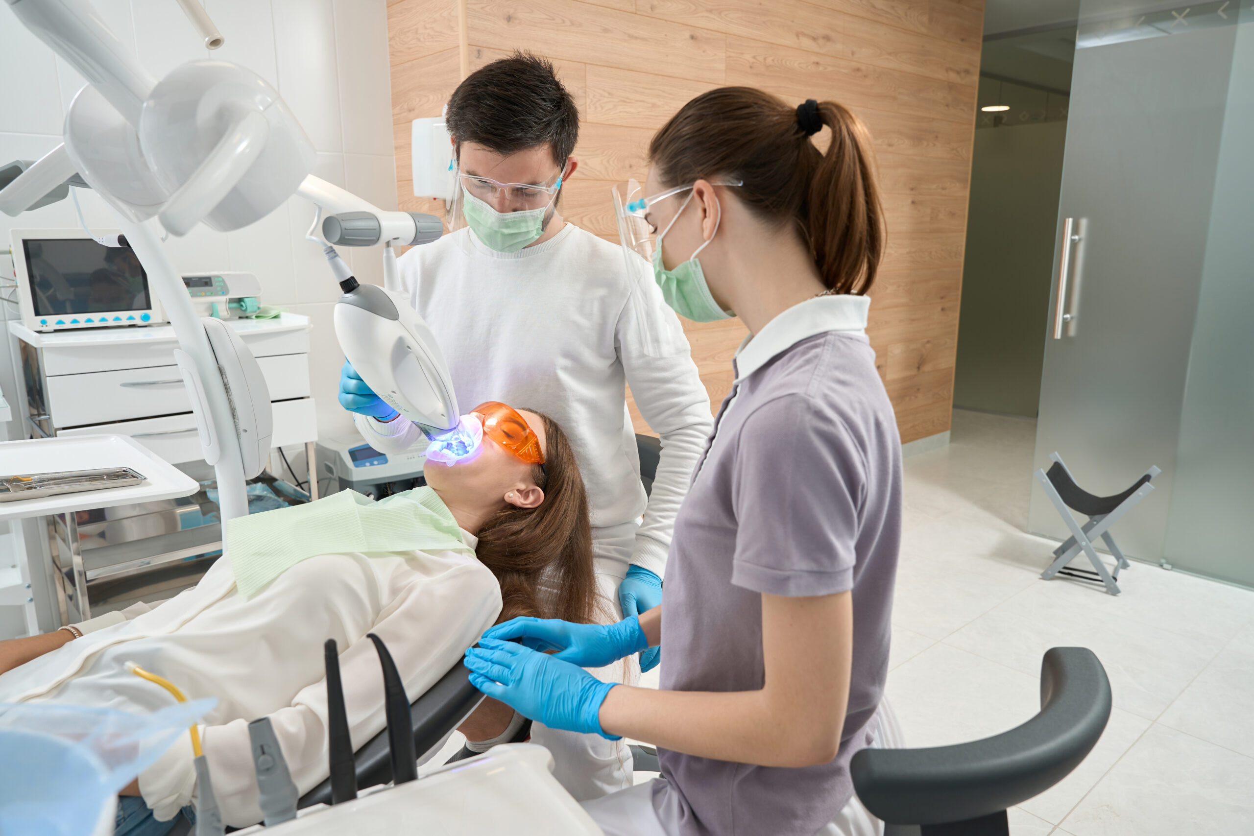 Stomatologist conducting dental procedure on young woman